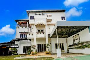 Edificio blanco con porche y balcón en Hotel O Banda Aceh near Masjid Raya Baiturrahman formerly Wisma Tsacita, en Banda Aceh