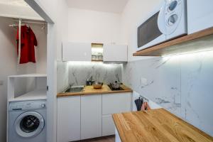 a small kitchen with a sink and a washing machine at Appartamento con terrazzo alla porte di Como in Lipomo