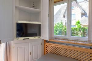 TV a/nebo společenská místnost v ubytování Haus Westsee EG mit Garten