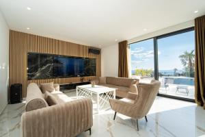 a living room with a couch and a tv at Villa London in Novalja