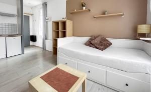 a living room with a white couch and a table at Studio Bien placé Centre Historique de Saintes in Saintes