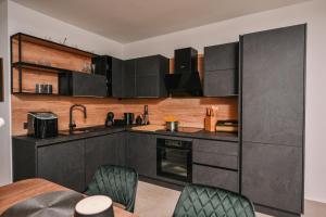 a kitchen with black cabinets and a table and chairs at Petra Hills Majestic in Opatija