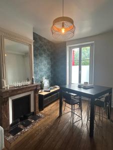 a dining room with a blue table and a mirror at Chez Léa-Magnifique maison au centre-ville in Chaumont