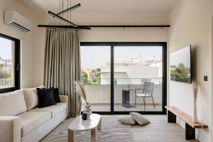 a living room with a couch and a large window at The Uptown Boutique Apartments in Athens