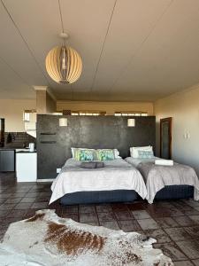 a large bedroom with two beds and a kitchen at Dewdrop Farm Stay in Ermelo