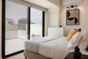 a bedroom with a bed and a large window at The Uptown Boutique Apartments in Athens