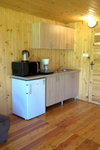 a kitchen with a white refrigerator and a microwave at Osrodek Nadmorski Osieki in Łazy