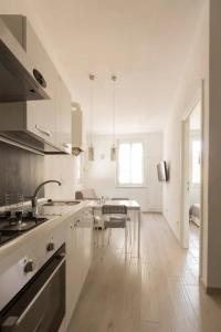a white kitchen with a sink and a table at Notte Serena in Riomaggiore