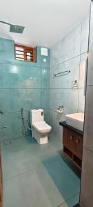 a bathroom with a toilet and a sink at Dr Indulekhas Ayurvedic Wellness & Rejuvenation in Tellicherry