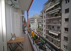 an apartment balcony with flowers and plants on it at Cozyhome 4 ILISIA in Thessaloniki