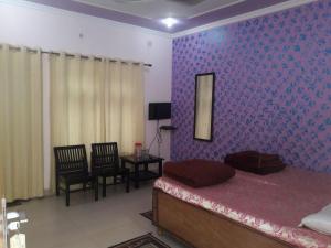 a bedroom with a bed and a mirror and chairs at Hotel Sandeep palace in Jāmb