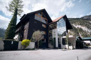 a black building with mountains in the background at Apart-Garni Innerwiesn in Mayrhofen