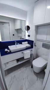 een witte badkamer met een wastafel en een toilet bij Orbi City 61 in Batoemi