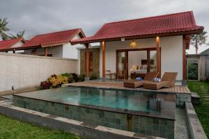 a villa with a swimming pool in front of a house at Sila Living Ubud in Sukawati