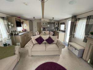 a living room with a couch and a kitchen at Static Home From Home in Winthorpe