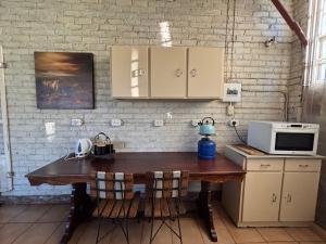 a kitchen with a wooden table with a microwave at Green Thumb Farm Stay in Ermelo