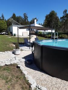 a swimming pool with an umbrella and a hot tub at Luxury Romantic Retreat with Hot Tub & Pool in Tábua