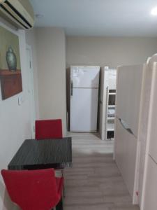 a kitchen with a table and red chairs and a refrigerator at Paxx Istanbul Hotel&Hostel in Istanbul