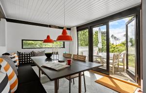 Una sala con mesa y un comedor con vista. en Awesome Home In Knebel, en Ørby