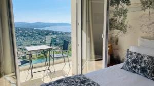 滨海卡瓦莱尔Villa Cacharelle Vue Mer Piscine的一间带床的卧室和一个可欣赏美景的阳台