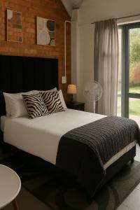 een slaapkamer met een groot bed en een raam bij Charming apartment With Private Balcony in Johannesburg