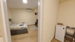 Un pequeño dormitorio con una cama y un pequeño refrigerador. en Center Point apartment, en Belgrado