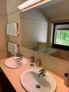 a bathroom with two sinks and a large mirror at L'Écrin de la Warche in Malmedy