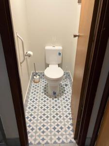 a bathroom with a toilet with a blue and white tiled floor at Walpole House in Walpole +26 photos