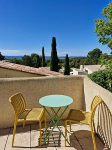 two chairs and a table on a patio at Maisonnette de charme dans domaine naturiste au pied du Mont Ventoux ! in Bédoin