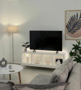 a living room with a flat screen tv on a white entertainment center at Idene Penthouse in Chania