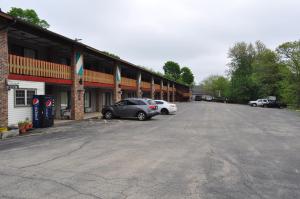 un estacionamiento con dos autos estacionados frente a un edificio en Kewanee Motor Lodge en Kewanee