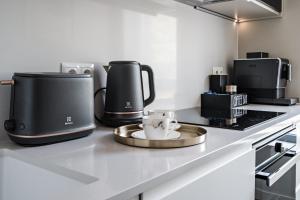 een keuken met twee koffiezetapparaten op een aanrecht bij Scala City Center Apartments with Parking by Lion Apartments in Gdańsk