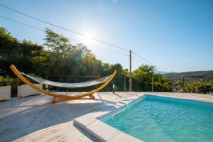 a hammock sitting next to a swimming pool at Villa Grace with private pool in Ascea