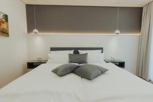 ein großes weißes Bett mit zwei Kissen darauf in der Unterkunft Parkhotel IV Jahreszeiten Kühlungsborn in Kühlungsborn