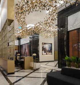 un hall d'entrée avec un grand lustre et un bureau dans l'établissement Silk Road Skyline Tashkent City, à Tachkent