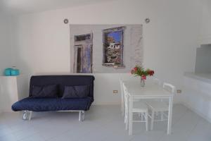 a dining room with a blue chair and a table at Roccette OndaTURCHESE, Vista Mare e Jacuzzi Privata in Costa Paradiso