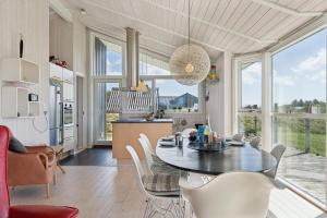 a kitchen and dining room with a table and chairs at Feriehus 1121 in Ringkøbing +22 photos