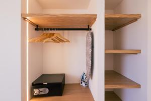a walk in closet with wooden shelves and a black box at Malacosta A - MC Apartments Ibiza in Ibiza Town