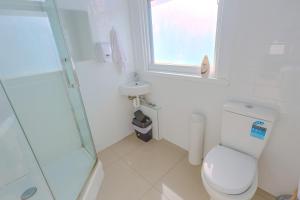 a white bathroom with a toilet and a sink at Crashpalace Napier in Napier