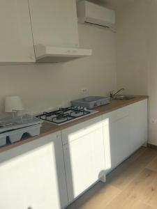 a kitchen with white cabinets and a stove top oven at Apartma Škorenjček in Prestranek
