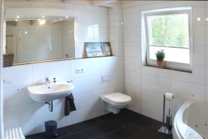 a white bathroom with a sink and a toilet at Zonnewende - Nordhorn in Nordhorn