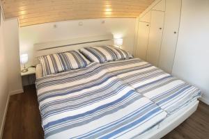 a bedroom with a bed with striped sheets at Zonnewende - Nordhorn in Nordhorn