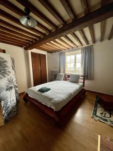 a bedroom with a large bed in a room at La Belle des champs - maison avec terrasse in Courseulles-sur-Mer