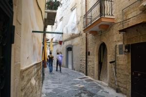 two men walking down a street in an alley at B&B S.Antonio in Bari