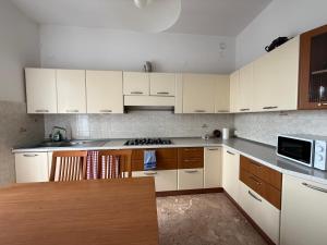 a kitchen with white cabinets and a wooden table at Appartamento Bellavista in San Martino
