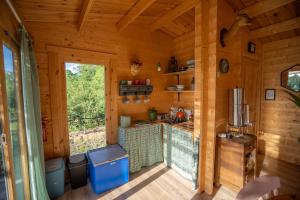 a kitchen in a log cabin with a window at Champs des Rêves in Busserolles +24 photos