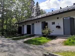 a white building with black doors on the side of it at Huoneisto grillausmahdollisuudella in Espoo