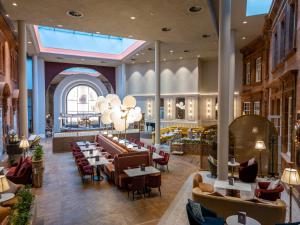 a restaurant with tables and chairs and a large window at The Caledonian Edinburgh, Curio Collection by Hilton in Edinburgh