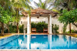 a swimming pool with a gazebo and a table at Coco Luxury Villa Mũi Né in Ấp Thiện Phước