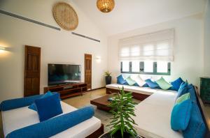 a living room with blue and white furniture and a flat screen tv at Coco Luxury Villa Mũi Né in Ấp Thiện Phước